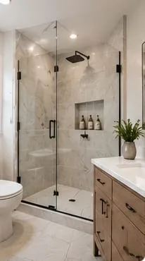 Guest bathroom after: glass walk-in shower with marble-look tile and a niche
